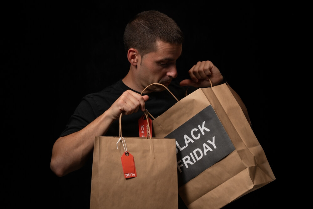 uomo sbircia nelle buste lo shopping del black friday